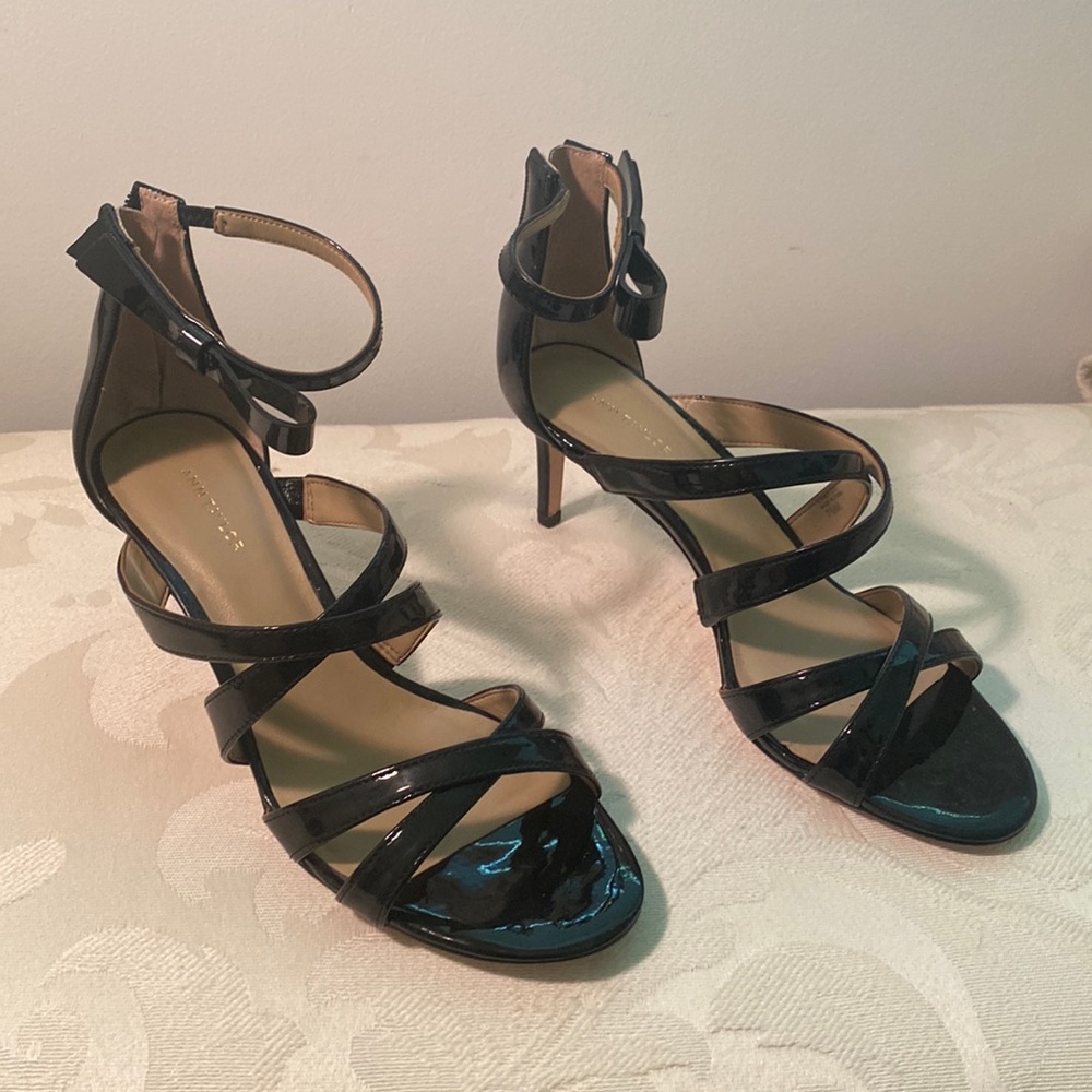 Black strappy sandals. Zip back. Fastens around ankle.